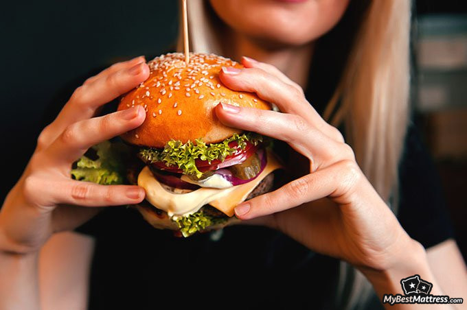 Eating before bed: woman eating a burger
