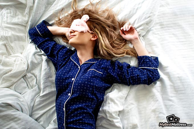 Best sleep mask: a woman sleeping with a sleep mask on.