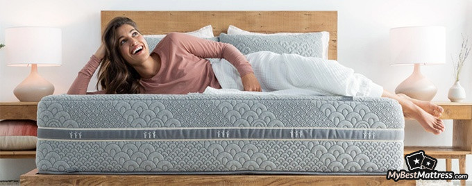 Brentwood Home mattress reviews: a woman is smiling and lying down on a Crystal Cove mattress Brentwood Home mattress reviews: a woman is smiling and lying down on a Crystal Cove mattress