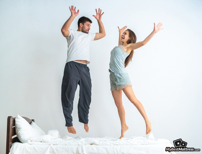 Brooklyn Bedding Aurora Review: a couple jumping on their bed.