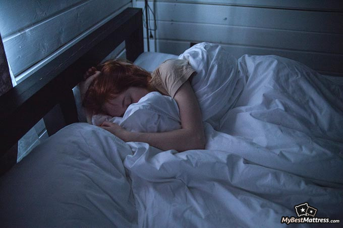 Cooling sheets: a girl tucked up in a bed.