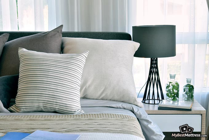 Cooling sheets: a bed with pillows in a lit room.