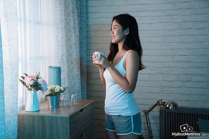 Green Tea Before Bed: Young woman preparing for bed with a cup of tea.