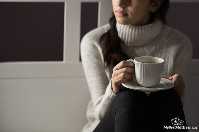 Green Tea Before Bed: Woman drinking green tea late at night.