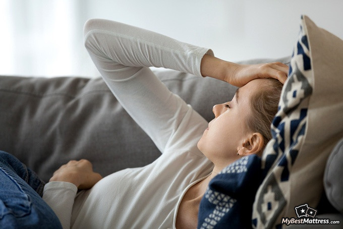 Sleeping on stomach: woman having a headache lying on the sofa. Sleeping on stomach: woman having a headache lying on the sofa.