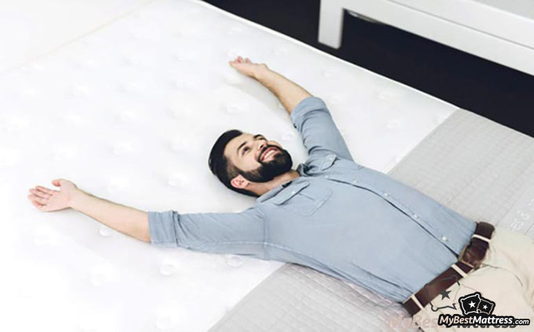 How to choose a mattress: a man laying on a bed. How to choose a mattress: a man laying on a bed.