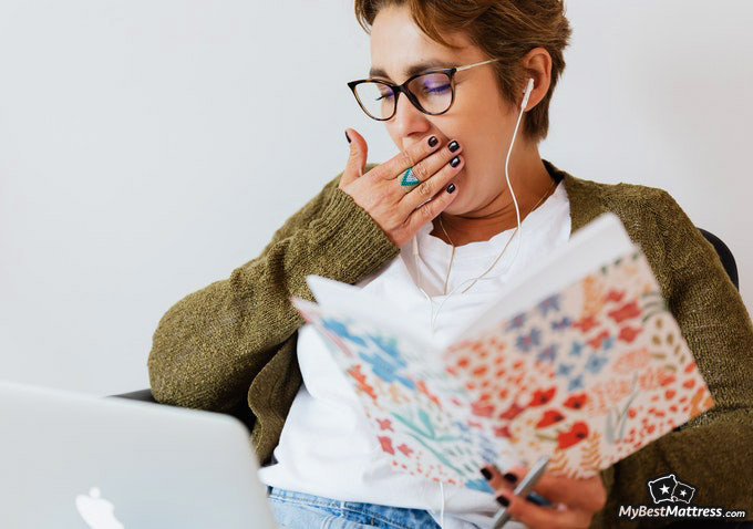 Hypnosis for sleep: woman yawning in bed.