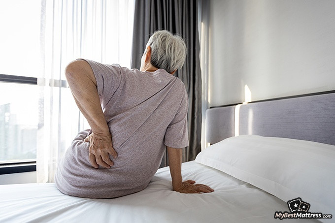 Luma Mattress Review: elderly woman getting up with back pain.