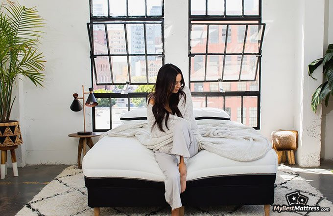 Luxi mattress review: woman sitting on the Luxi mattress. Luxi mattress review: a woman sitting on the Luxi mattress.