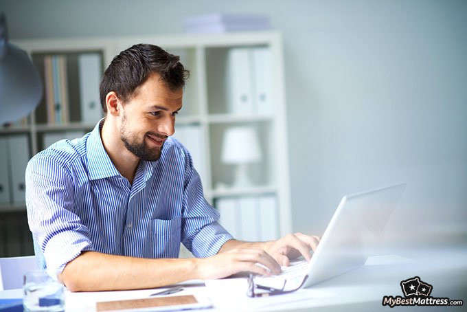 how to sell mattresses: man using a computer