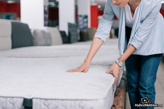 Mattress firmness scale: woman checking mattress Mattress firmness scale: woman checking mattress