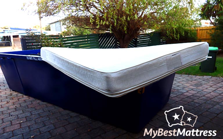 Mattress disposal: mattress in a garbage container. Mattress disposal: mattress in a garbage container.