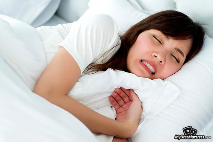Mouth guard for teeth grinding: a woman sleeping and grinding her teeth.
