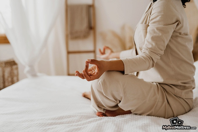 Night terrors vs nightmares: a woman is meditating in bed Night terrors vs nightmares: a woman is meditating in bed