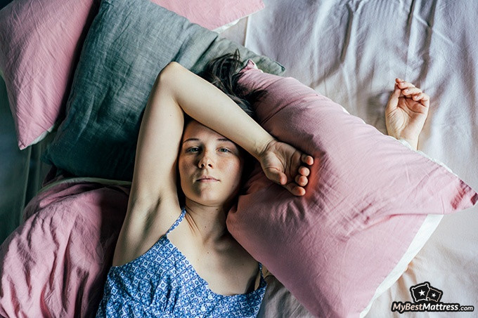 Night terrors vs nightmares: a woman is looking ahead with a tired expression Night terrors vs nightmares: a woman is lying on the bed and looking ahead with a tired expression