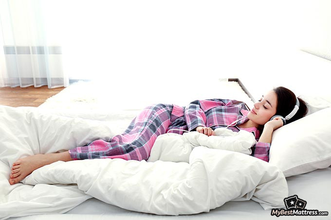 Noise-canceling headphones for sleeping: a woman sleeping with headphones on.