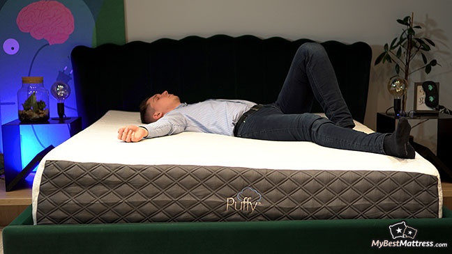 Puffy mattress reviews: back sleeper lying on the bed.