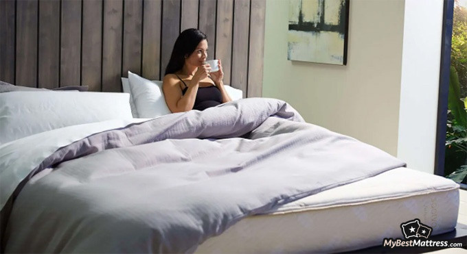 Saatva Latex Hybrid Review: woman sipping tea in bed.