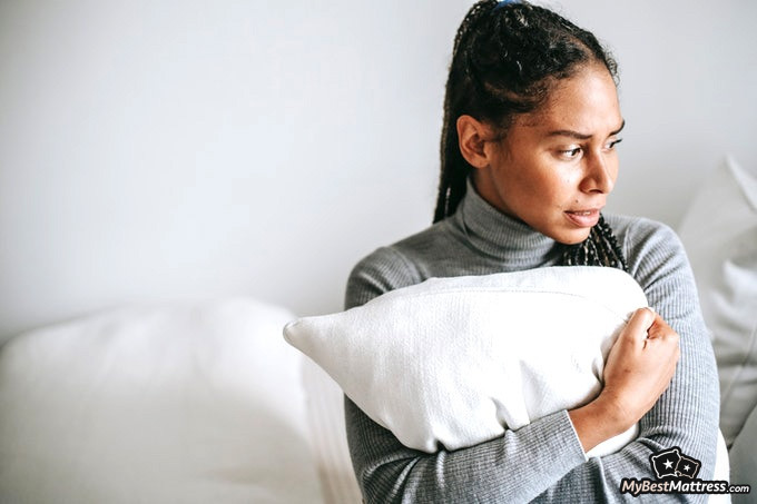 Sleep hallucinations: a worried female holding pillow Sleep hallucinations: a worried female holding pillow