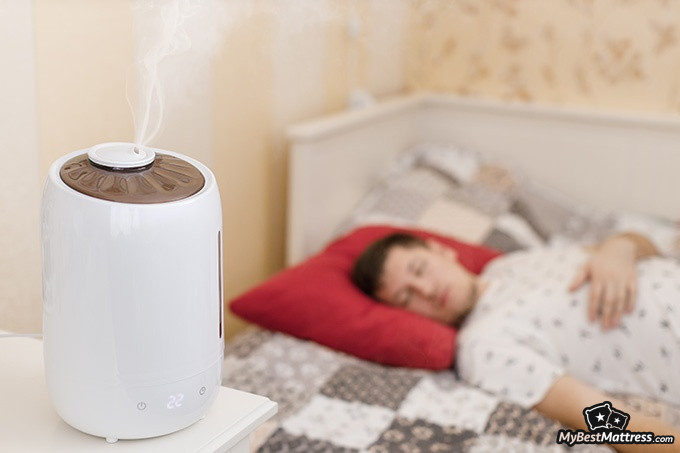 Sleep Learning: man sleeping with a diffuser next to the bed.