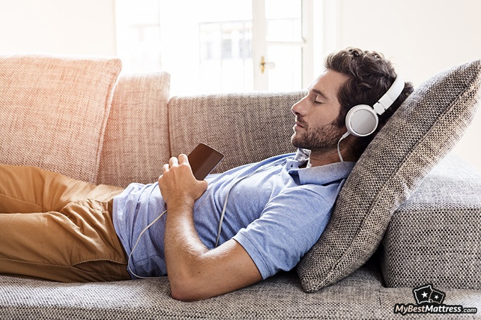 Sleep Learning: guy sleeping on a couch with headphones on.