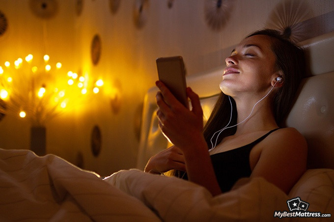 Sleep Learning: woman listening to music in bed.