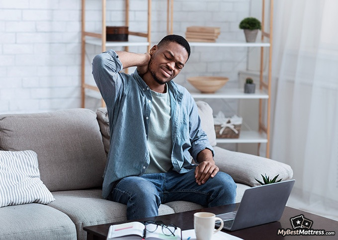 Sleeping Sitting Up - a man waking up with neck pain.