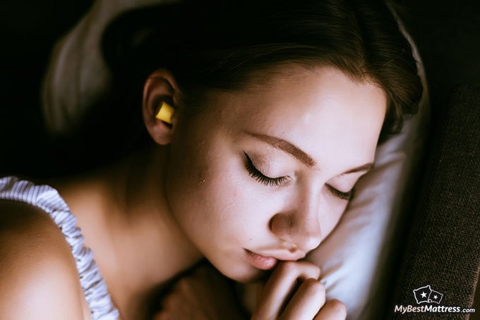 Natural sleep aid: woman sleeping with earplugs Natural sleep aid: woman sleeping with earplugs