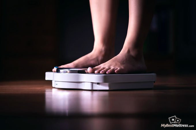 how to make a weighted blanket: woman weighing herself