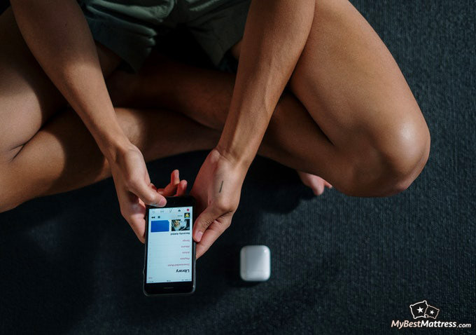 Working out before bed: person using a phone in the gym. Working out before bed: person using a phone in the gym.