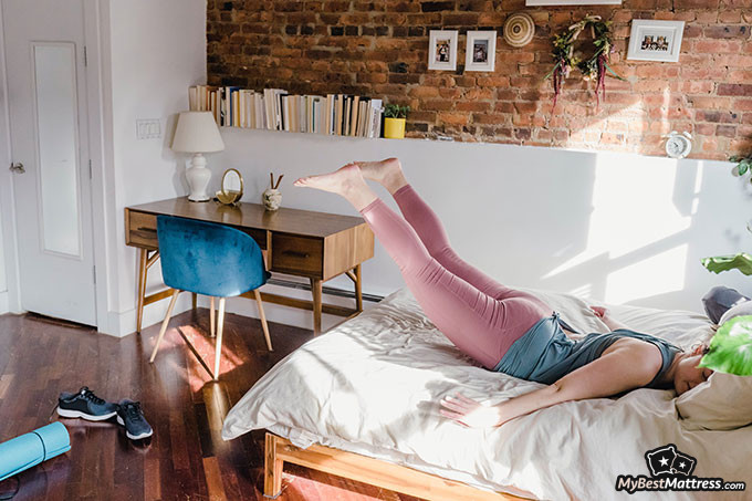 Yoga before bed: a woman doing yoga on her bed.