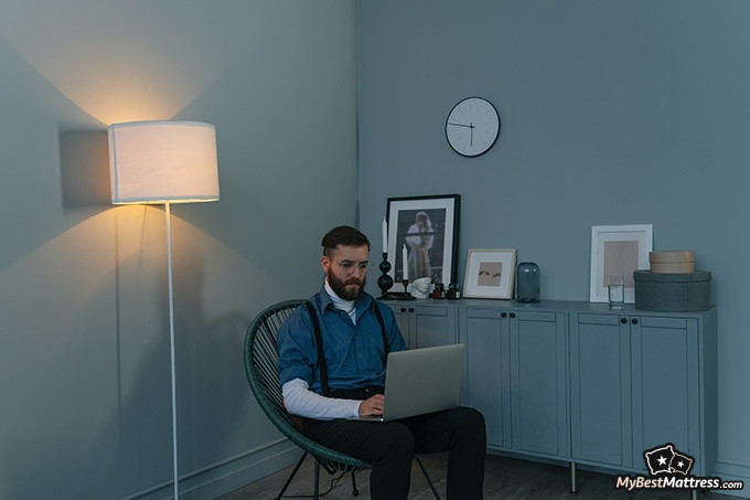 Yoga before bed: a man sitting in the chair working on his laptop.
